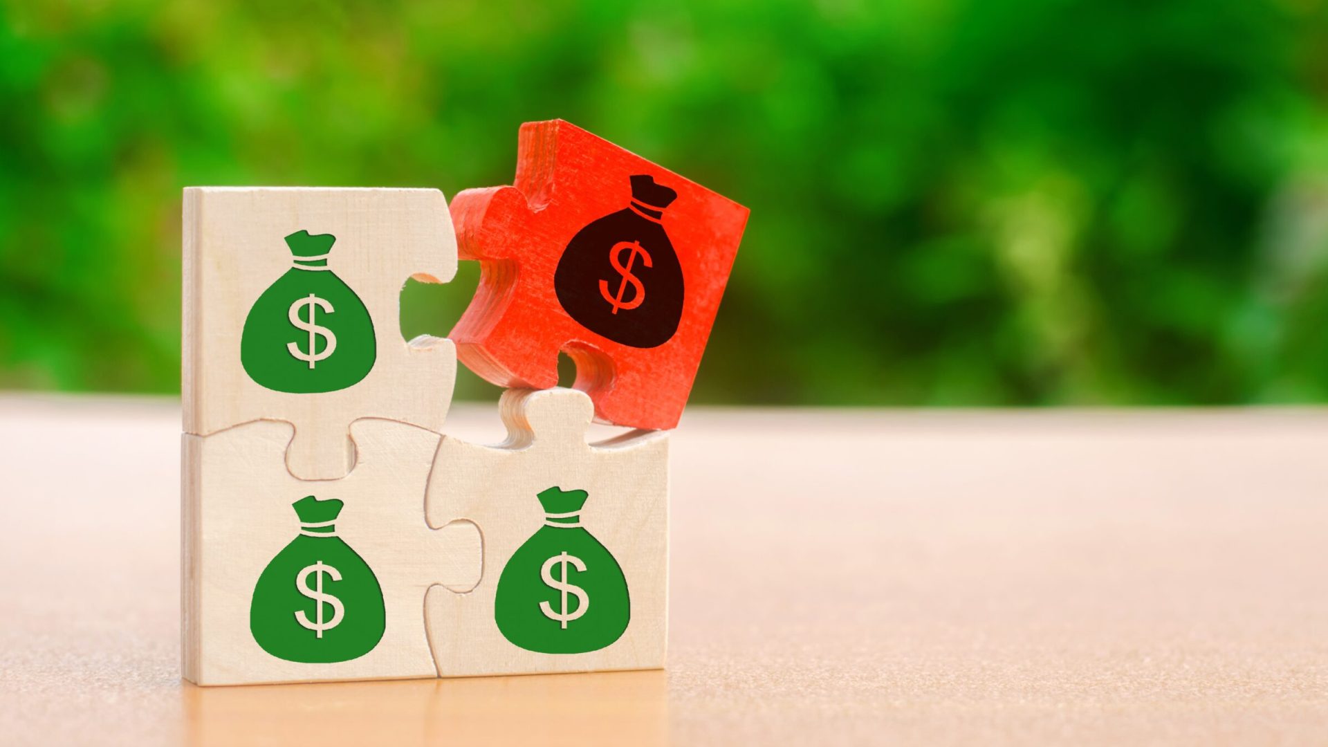 Wooden puzzles with the image of money. Withholding money and commission. Tax and taxation. The taxes burden. Net income. Costs. Ebitda. Business and Finance. Profit management. Investments